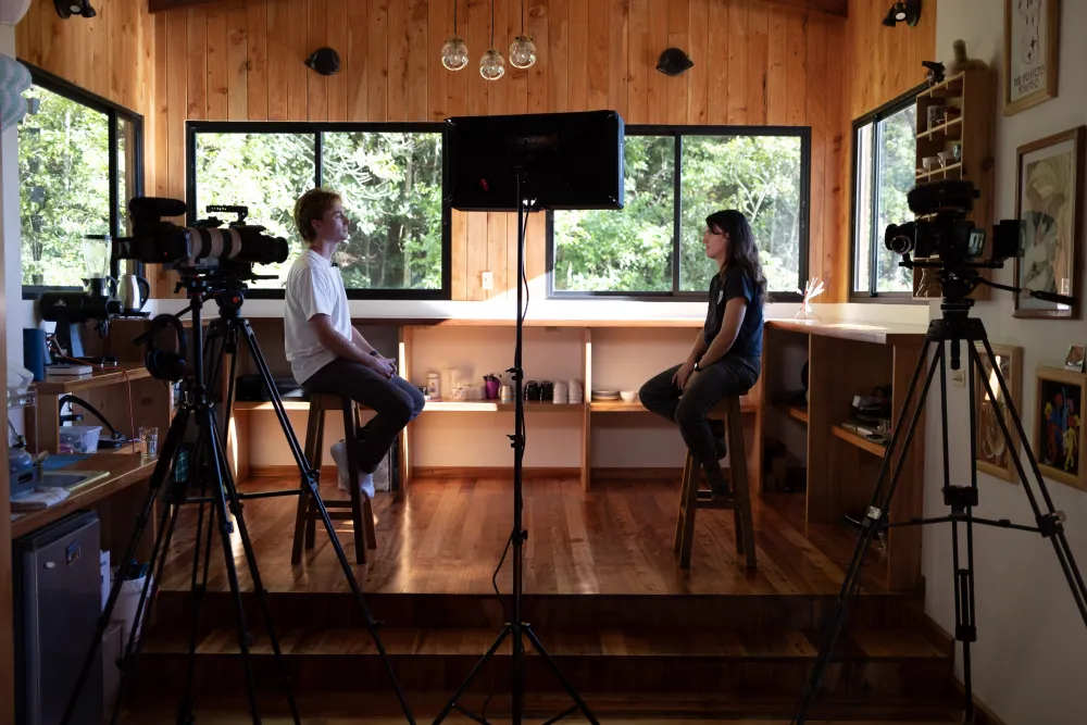 Cole recording a Buy The Drip conversation on a Chiriquí farm, two cameras and a light set up around the pair.